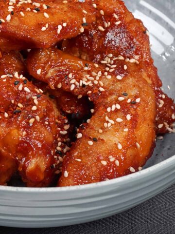 A close up view of Korean style spicy chicken wing.