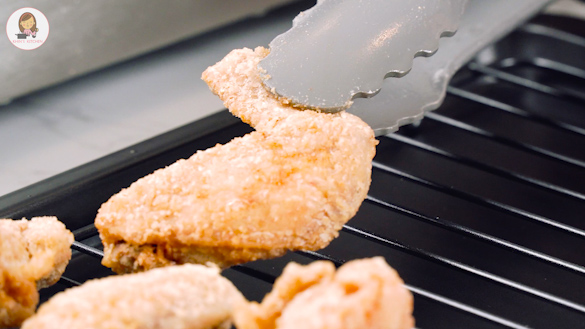 Fried chicken wings on the black colour cooling rack. 