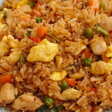 A blue color plate filled with spicy fried rice.