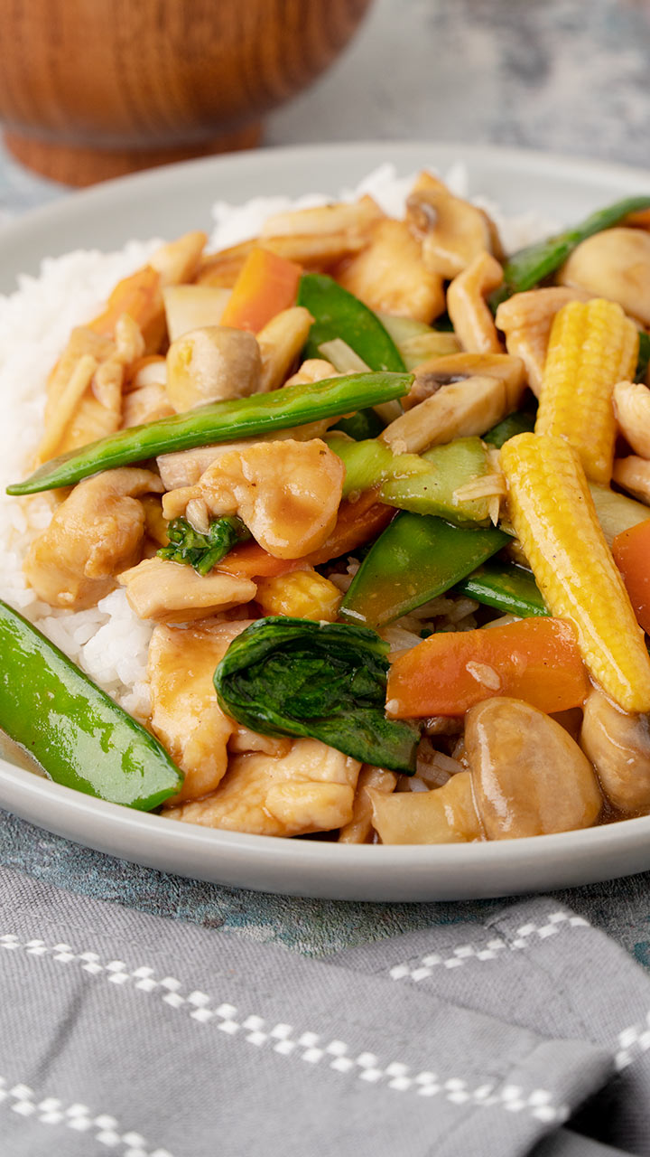 A grey plate containing chicken chop suey with rice. 