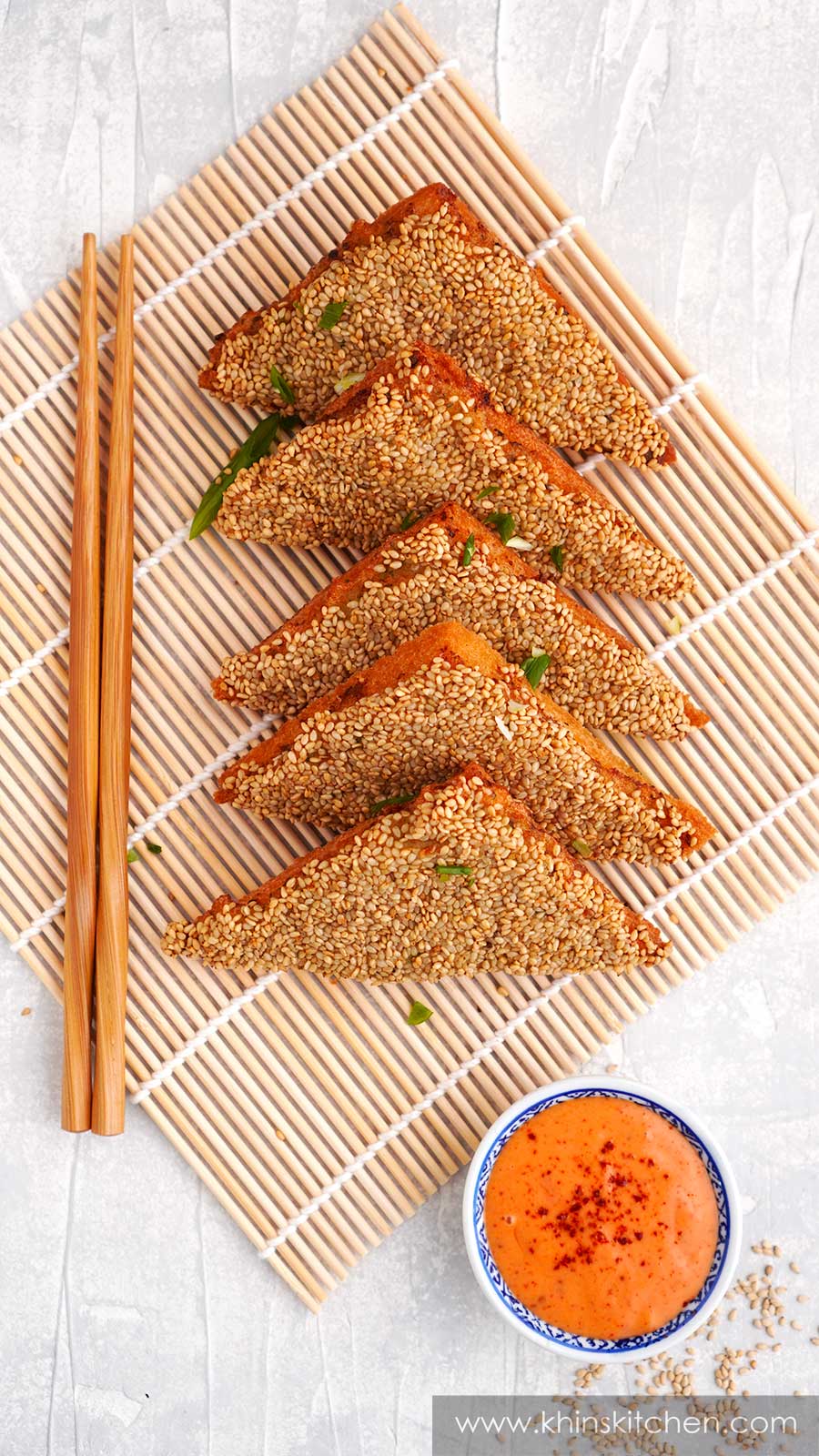 Fried prawn toast displayed on the bamboo placemat. Wooden chopstick on the side. 