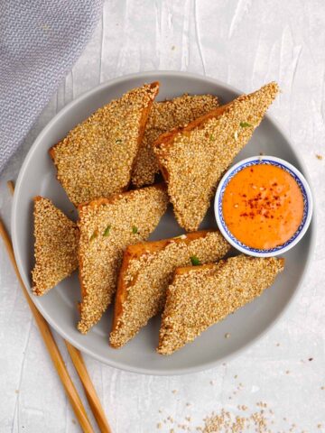 triangle shape fried bread topped with minced prawns and sesame seeds