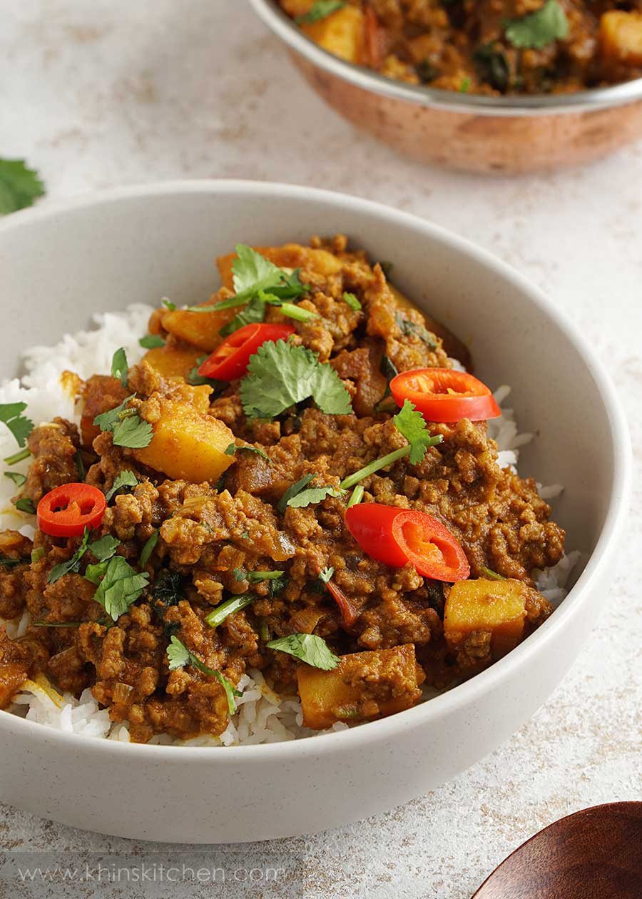 minced beef curry served over white rice in a cream colour bowl