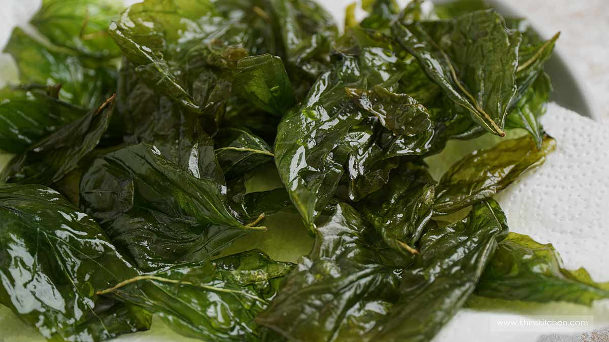 Fried basil leaves on the white kitchen towel.