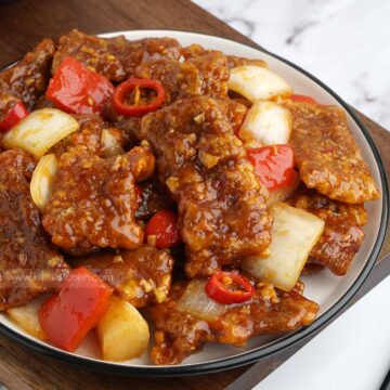 A full plate of beijing beef on the white plate.