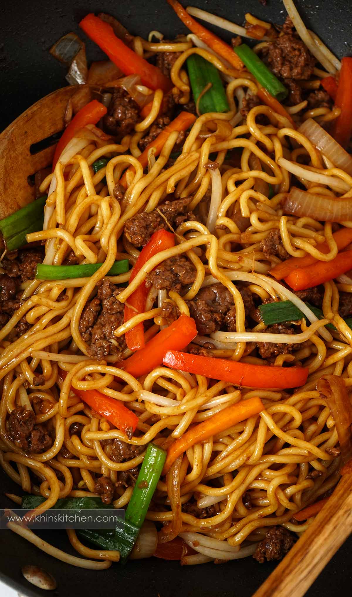Close up of beef chow mein noodles in a skillet, containing stir fry noodles, ground beef and vegetables.