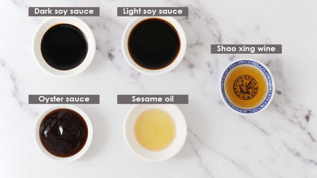 Labelled 5 different types of sauces in small white dipping bowl on the white surface.