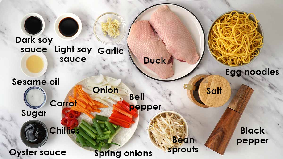 Labelled ingredients for duck chow mein laid out on the white table.