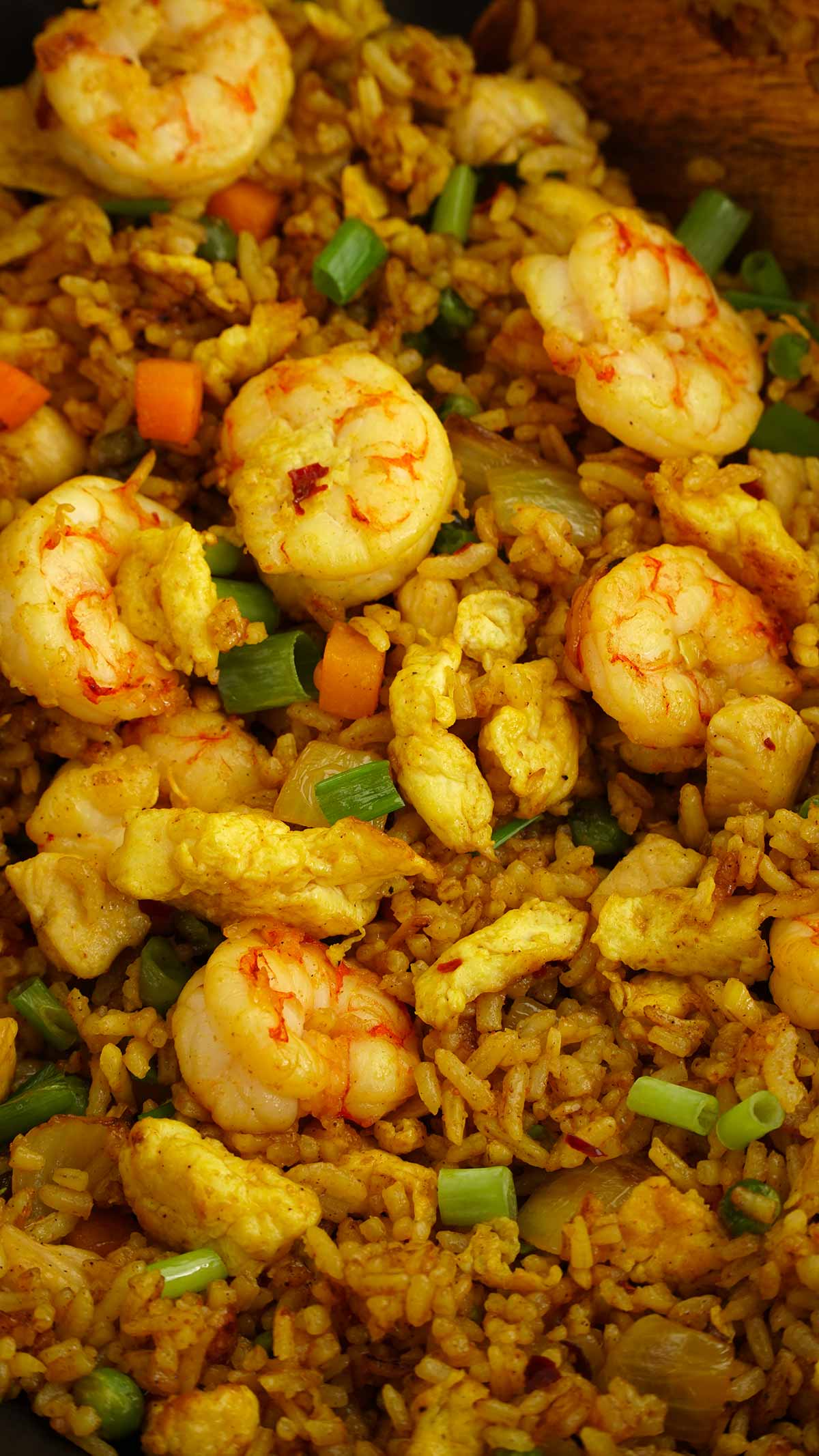 Close up view of fried rice with prawn, chicken and eggs in the pan.