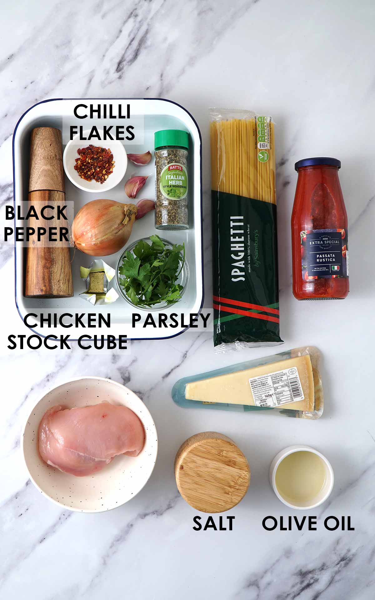 Labelled chicken pasta ingredients displayed on the white table. 