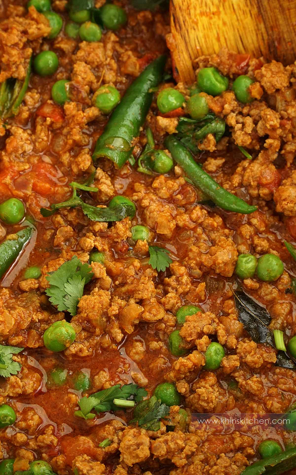 Close up photo of lamb keema curry with green peas, green chillies, coriander. 