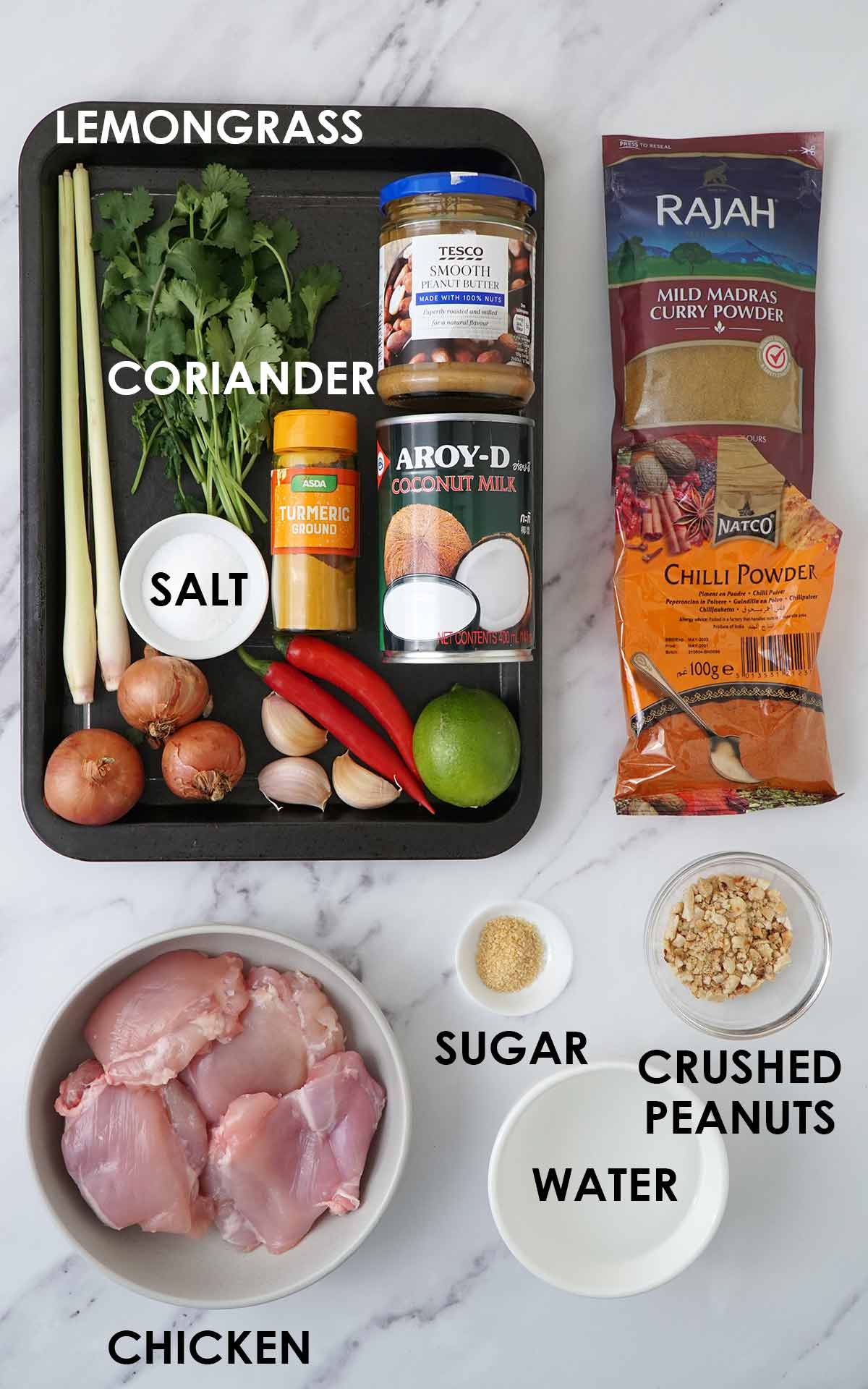 Labelled peanut butter chicken ingredients, displayed on the white table.  