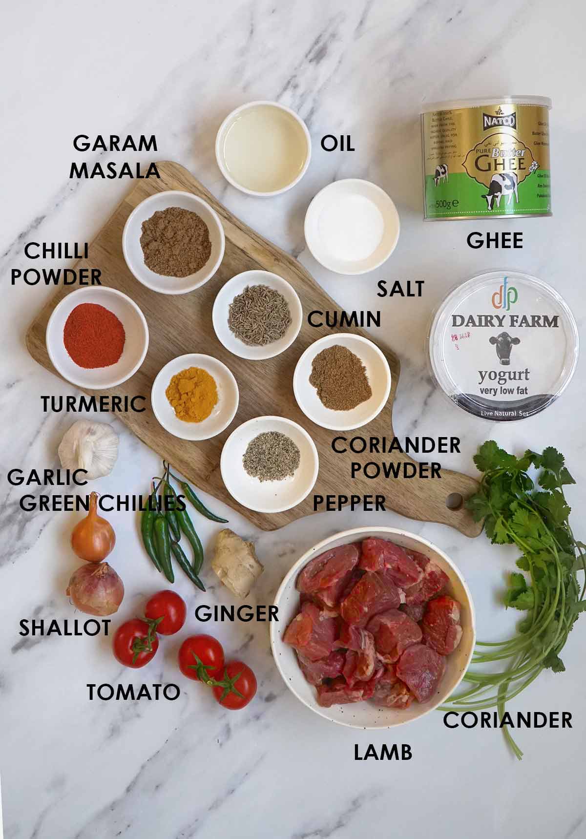 Labelled ingredients of making lamb curry, displayed on the white table. 