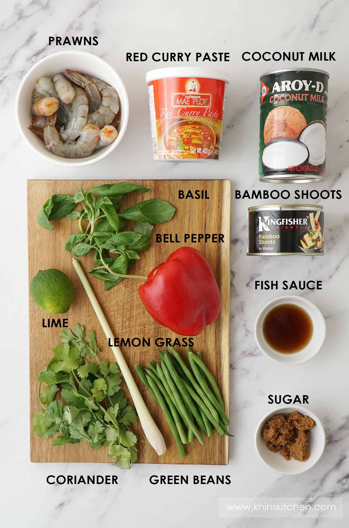 Labelled ingredients of making prawn red curry displayed on the white table. 