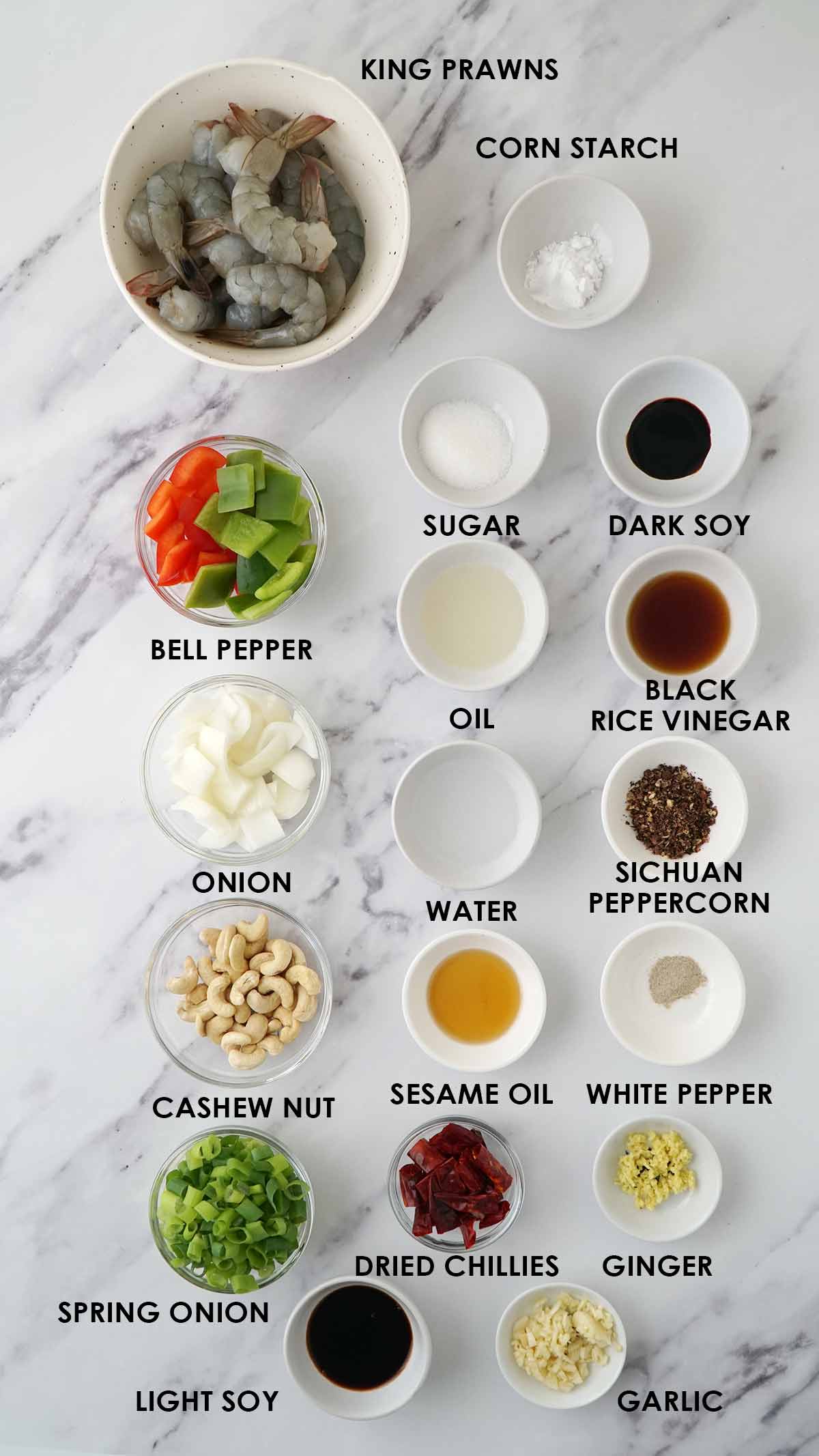 Labelled ingredients of making stir fry prawns displayed on the white table.