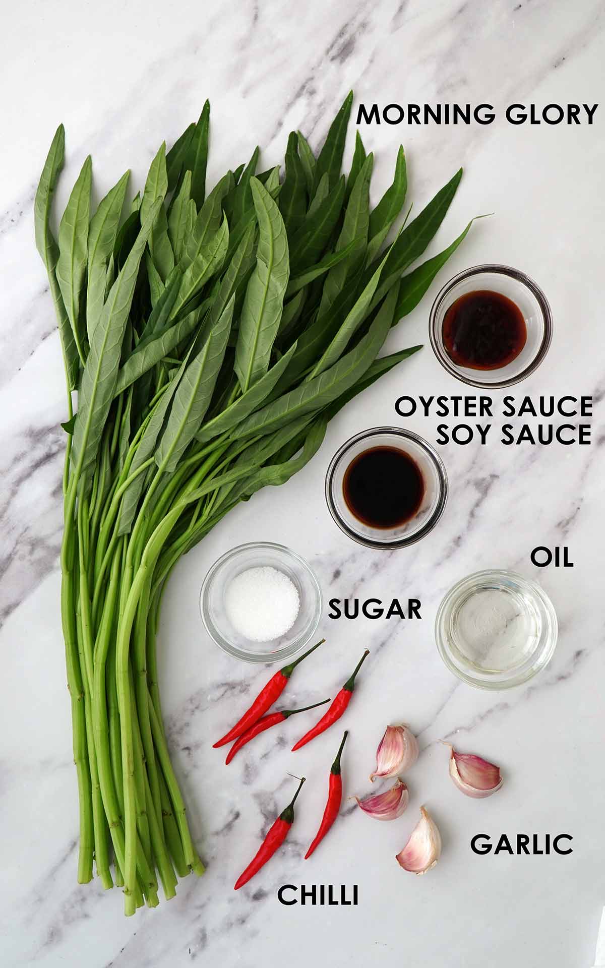 Labelled ingredients of making water spinach stir fry displayed on the white table. 