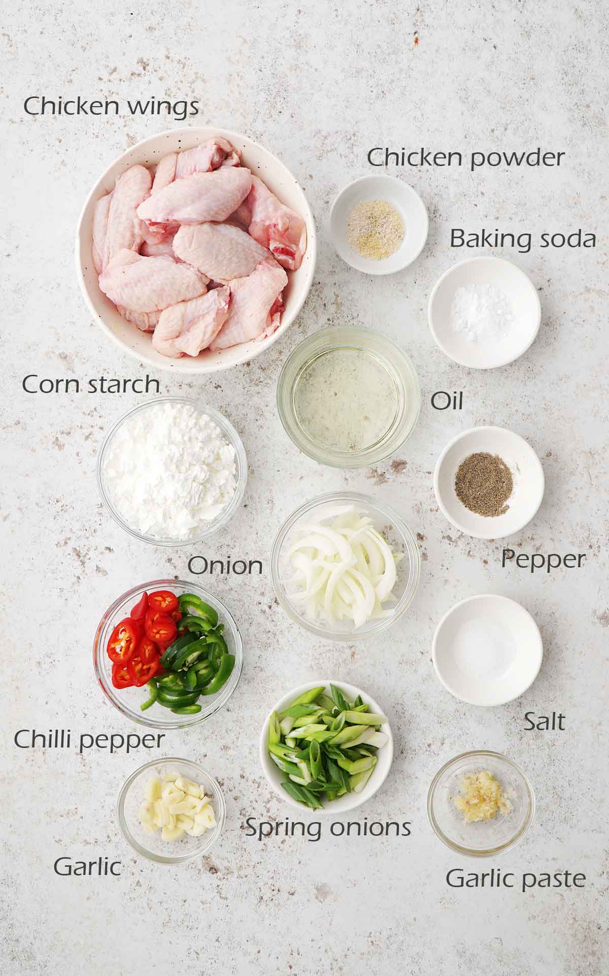 Labelled ingredients of making salt and pepper wings displayed on the white table.
