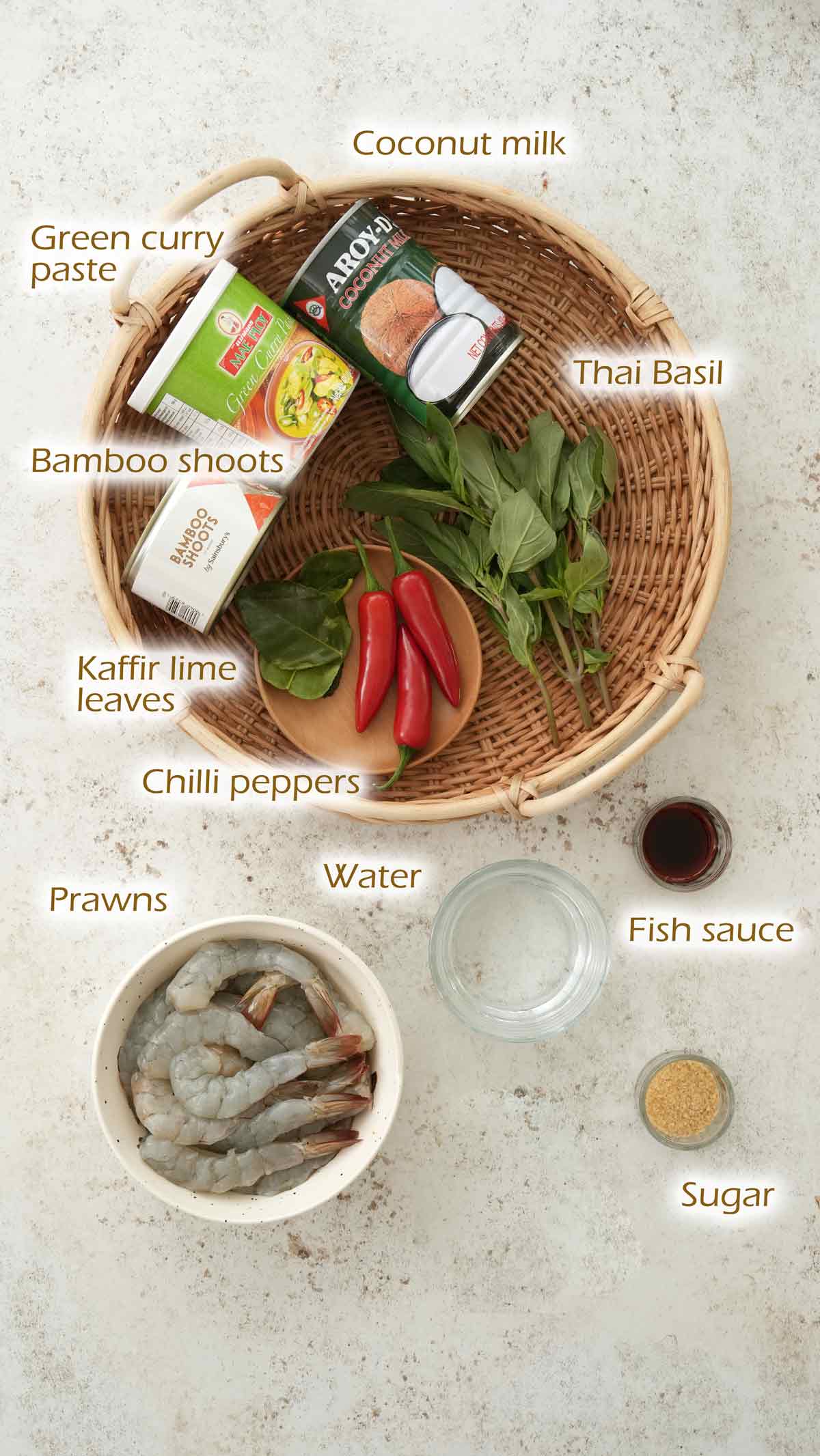 Labelled ingredients displayed on the white table and round rattan tray. 