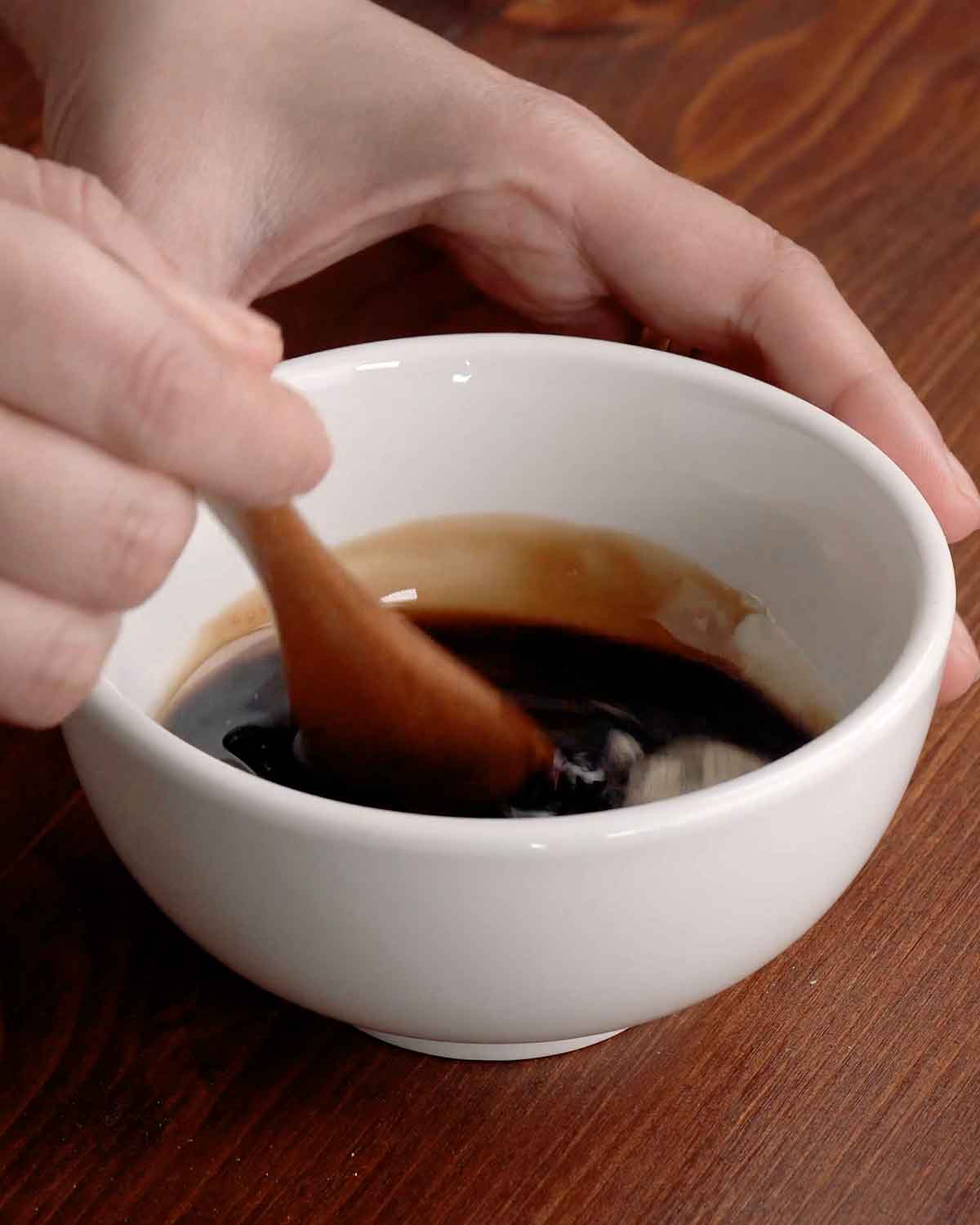 A white bowl containing stir fry sauce mixture.