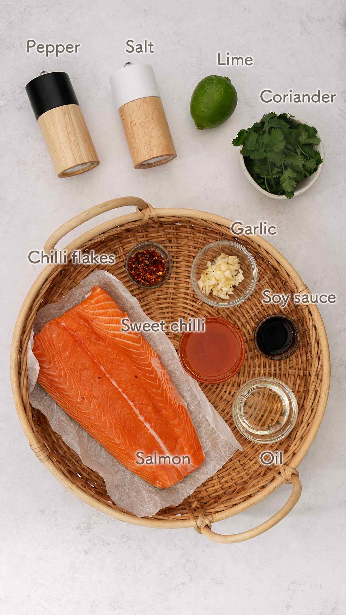 Labelled ingredients of making sweet chilli salmon displayed on the white table.