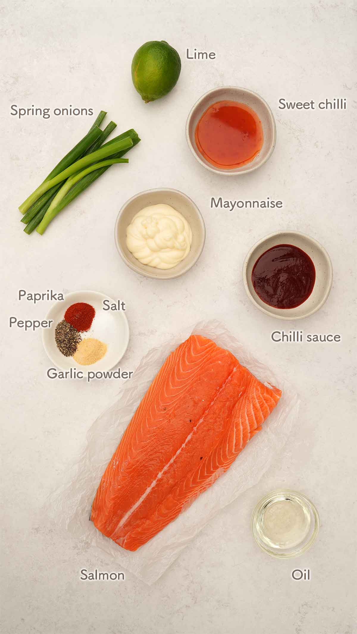 Labelled ingredients of making bang bang salmon displayed on the white table.