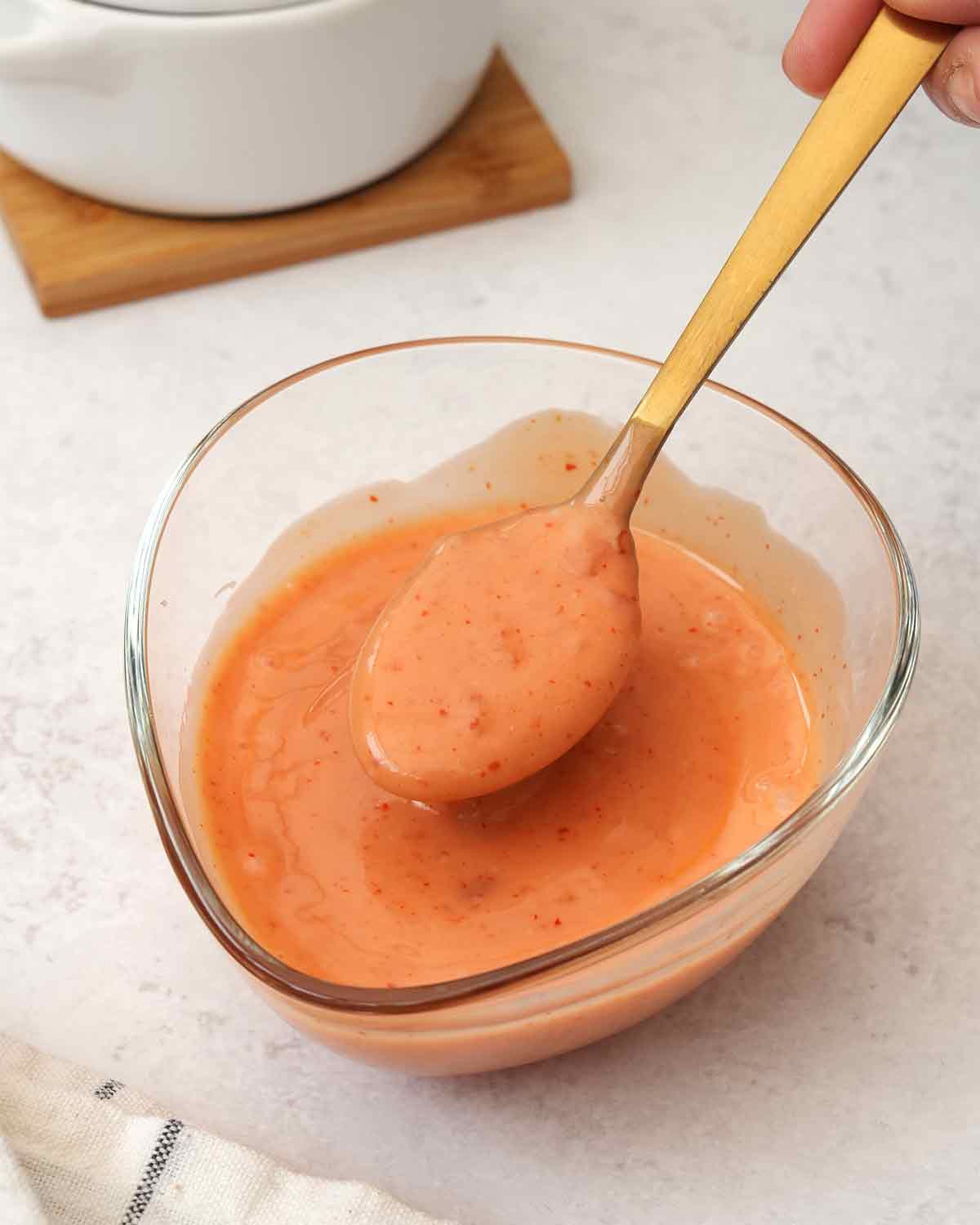 A dipping sauce bowl containing creamy pink colour bang bang sauce.
