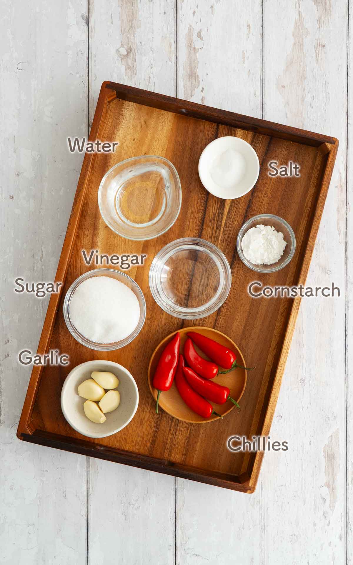 Labelled chilli sauce ingredients displayed on the white table. 