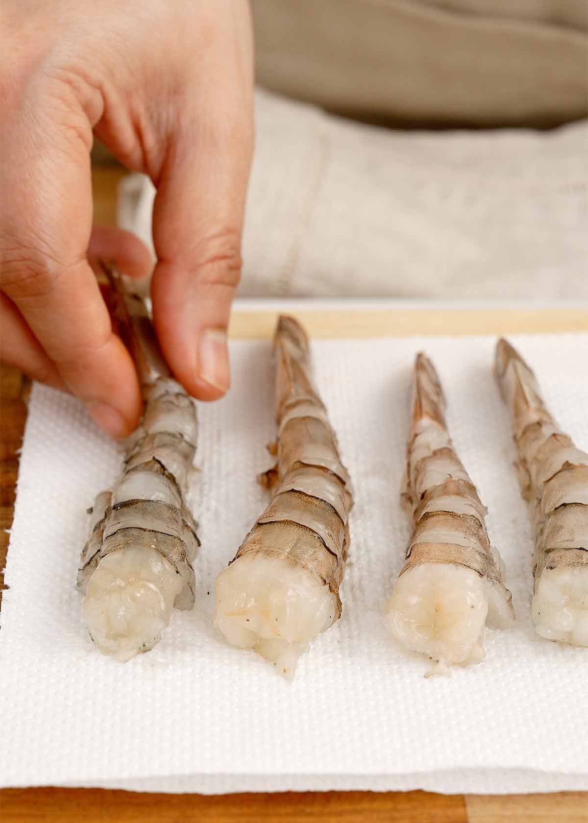 Peeled and deveined shrimps placed on the white paper towel.