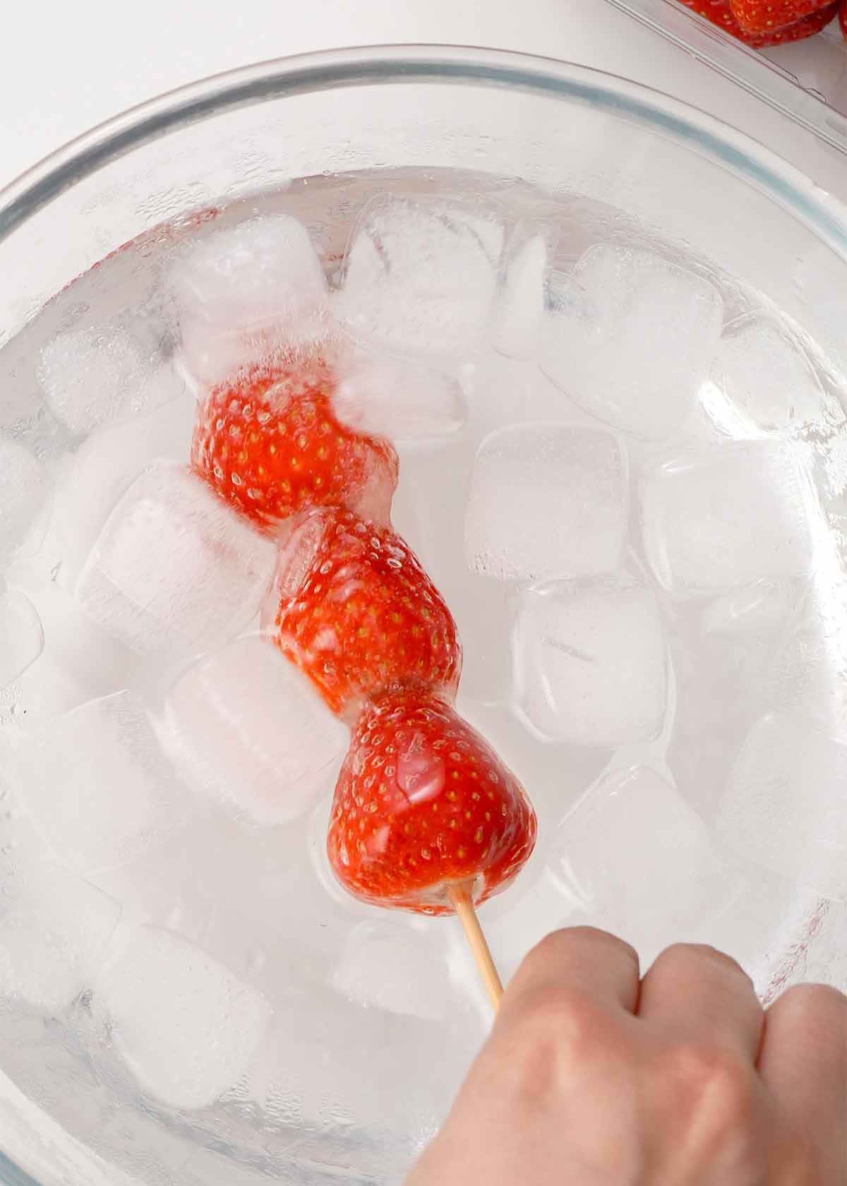 A picture of sugar coated candied fruit dipped in the ice water. 