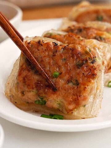 An image of fried crispy rice paper dumplings in a white plate.