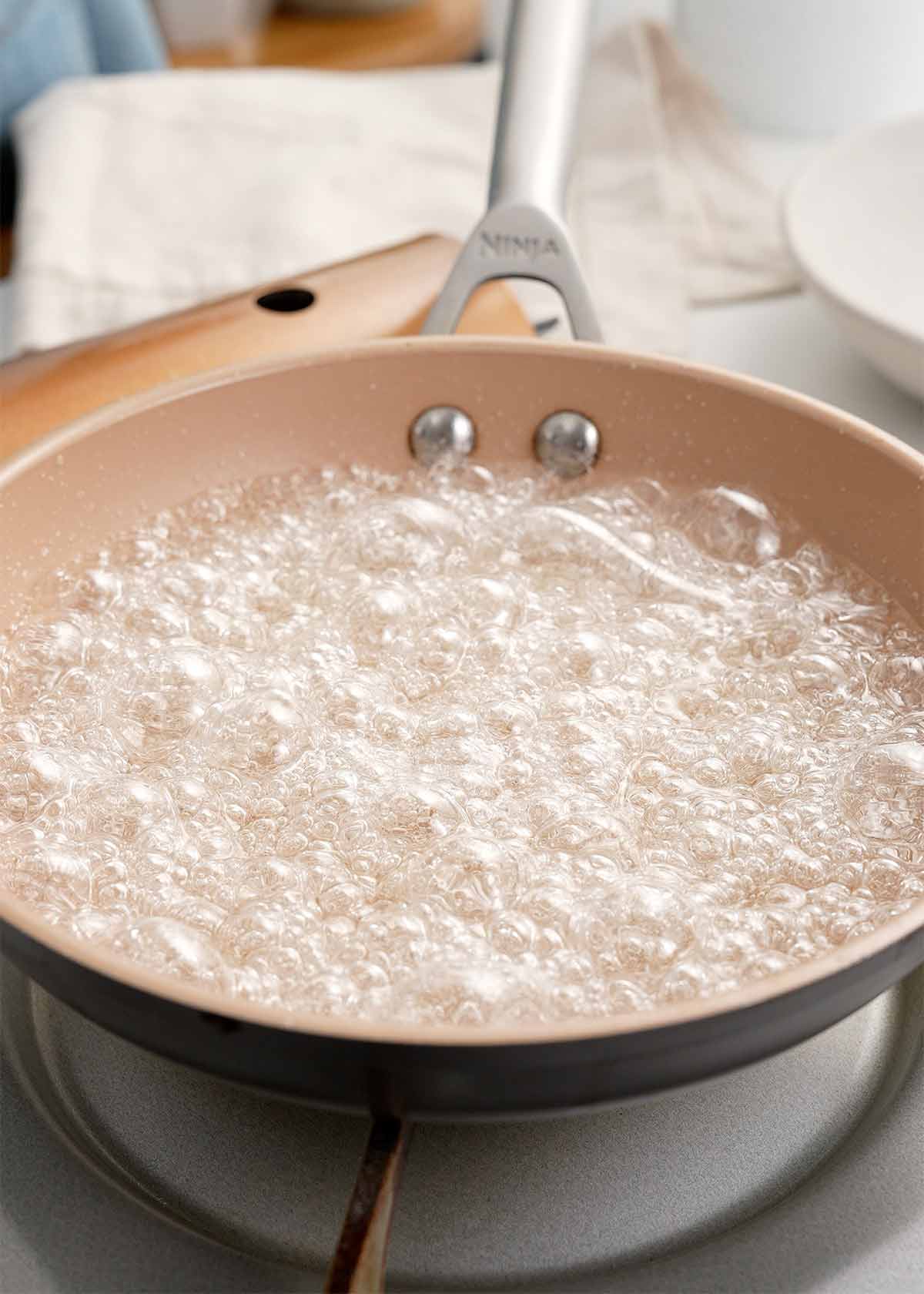 A picture of boiling sugar and water in a saucepan. 