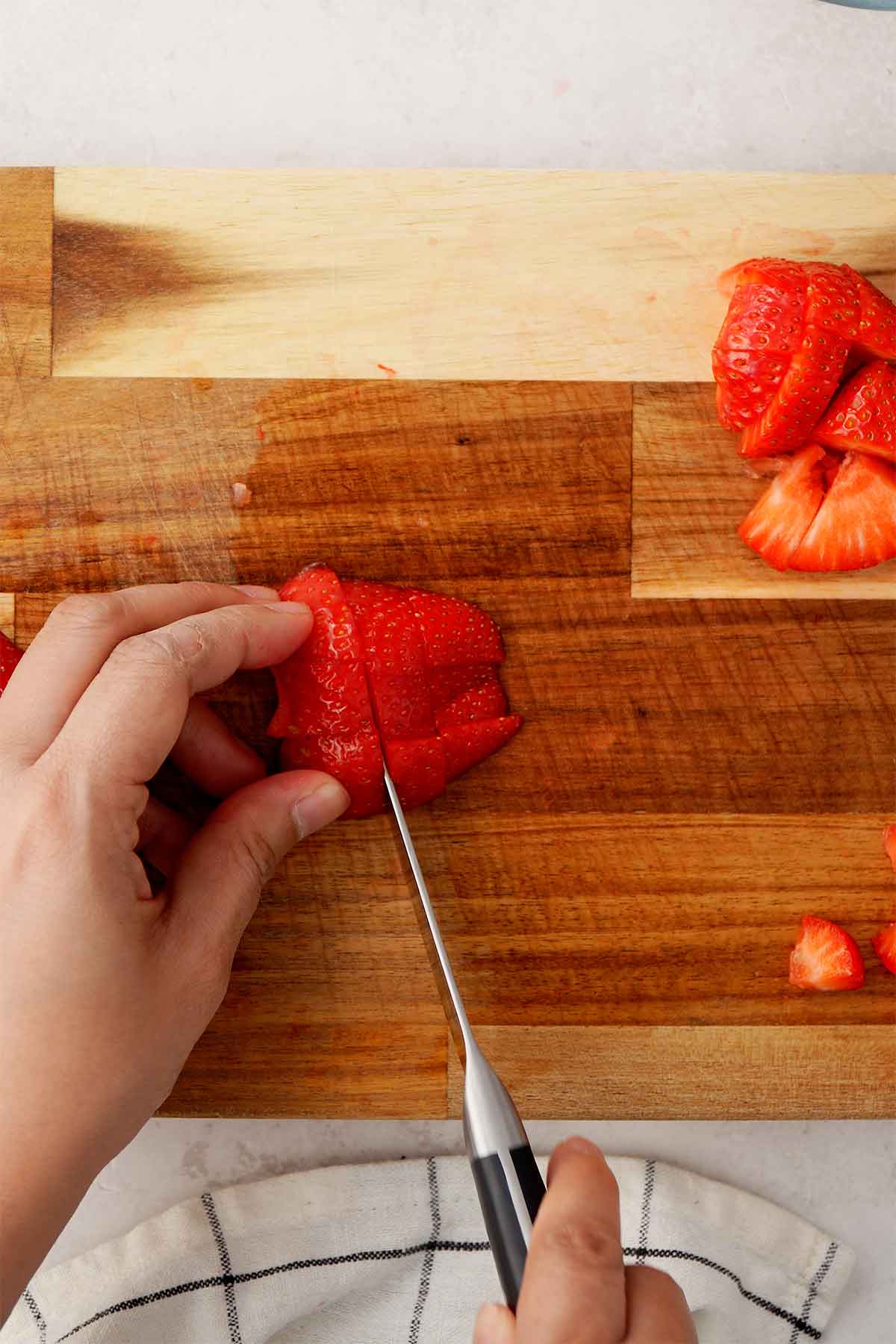 An image of cutting strawberries into small chunks. 