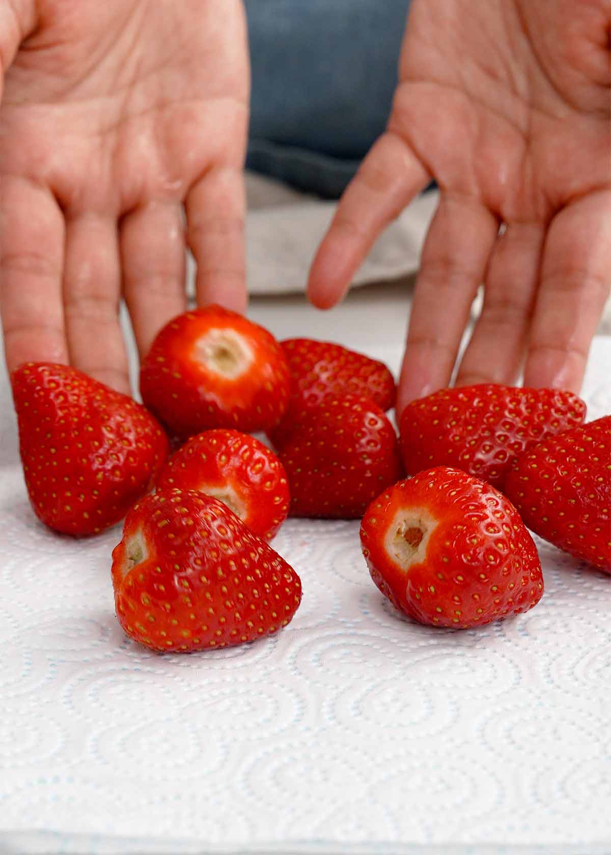 An image showing how to pat dry strawberries on paper towel. 