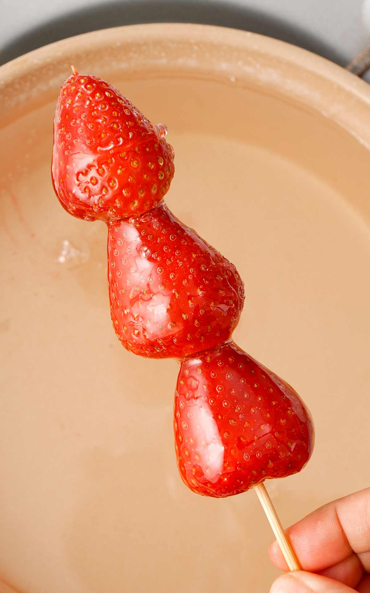 A picture of sugar syrup coated strawberry tanghulu. 