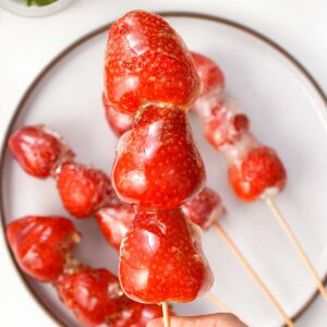 A picture of glossy sugar syrup coated strawberry tanghulu.