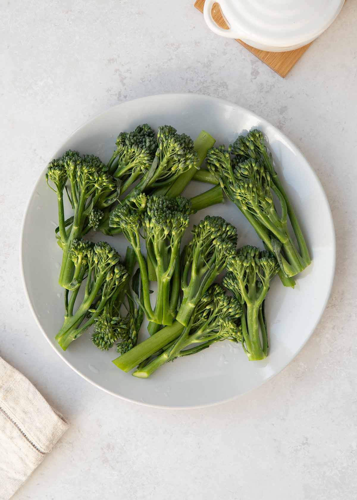 Washed and cut broccoli pieces displayed on the white plate.