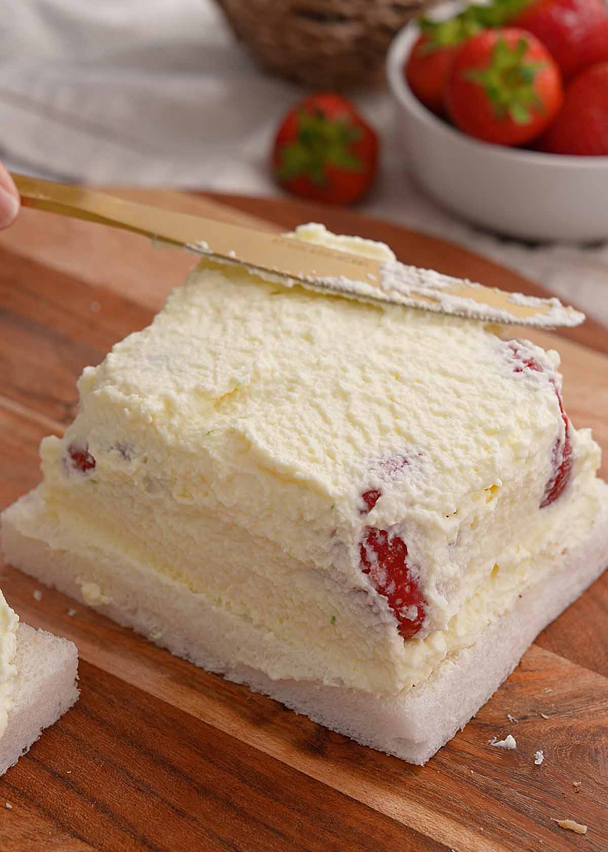 An image showing layers of bread, cream, and strawberries.