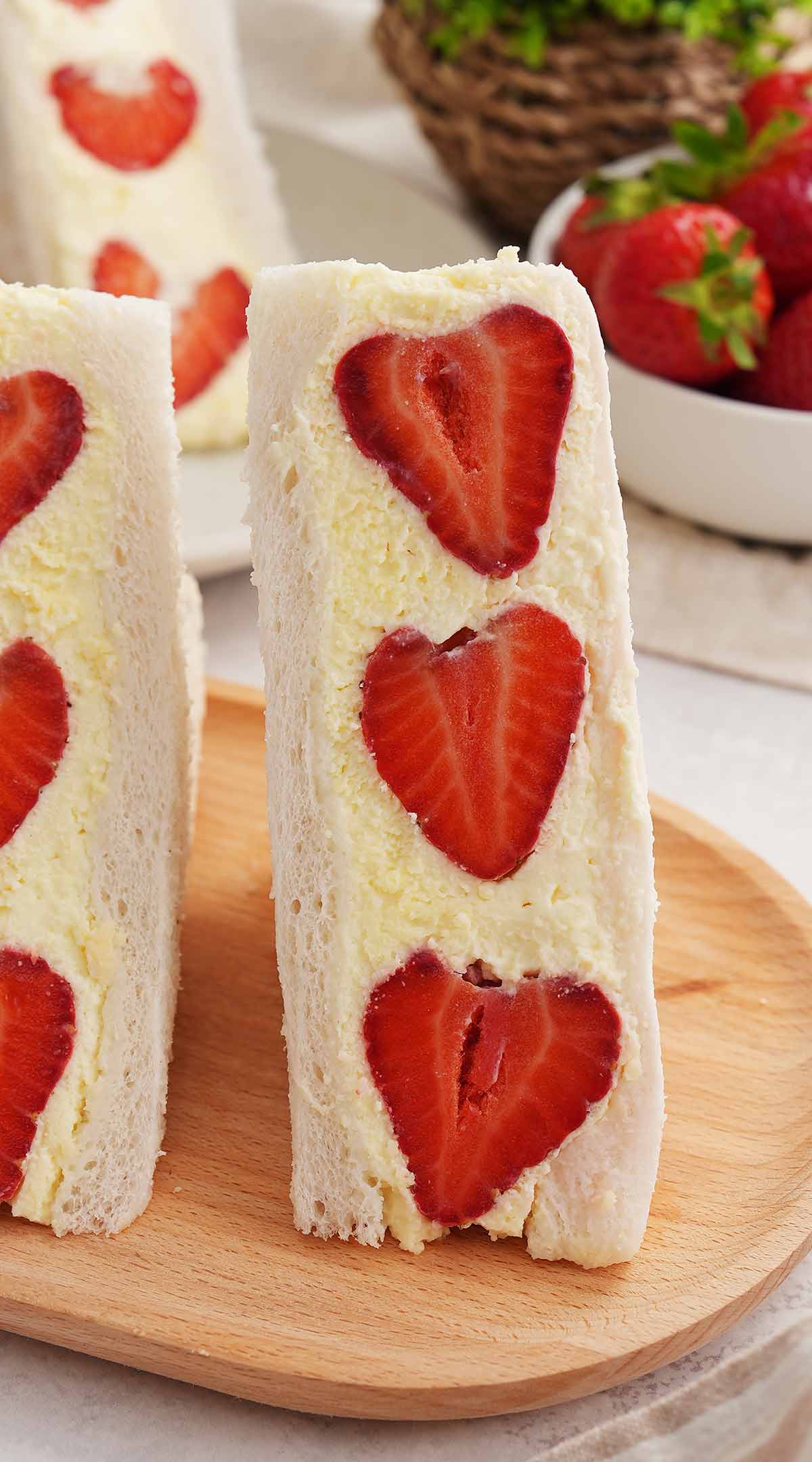 An picture of half of white bread sandwich filled with strawberries and cream.