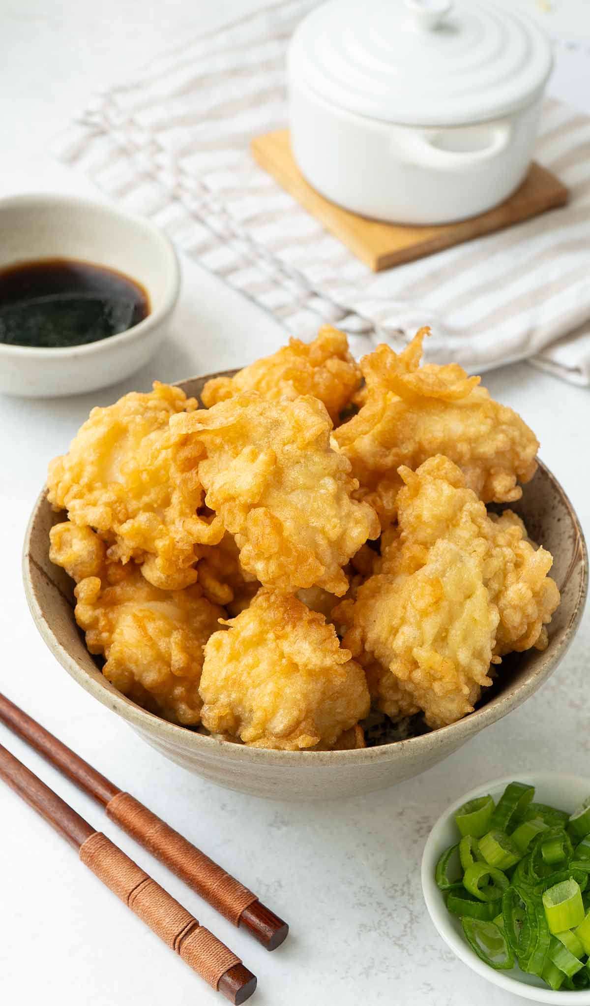 A bowl containing tempura battered fried fish pieces.