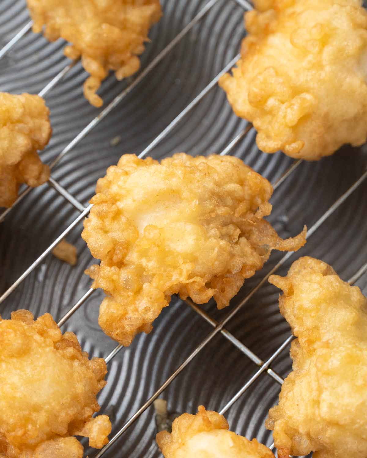 Fried fish pieces displayed on the cooling rack.
