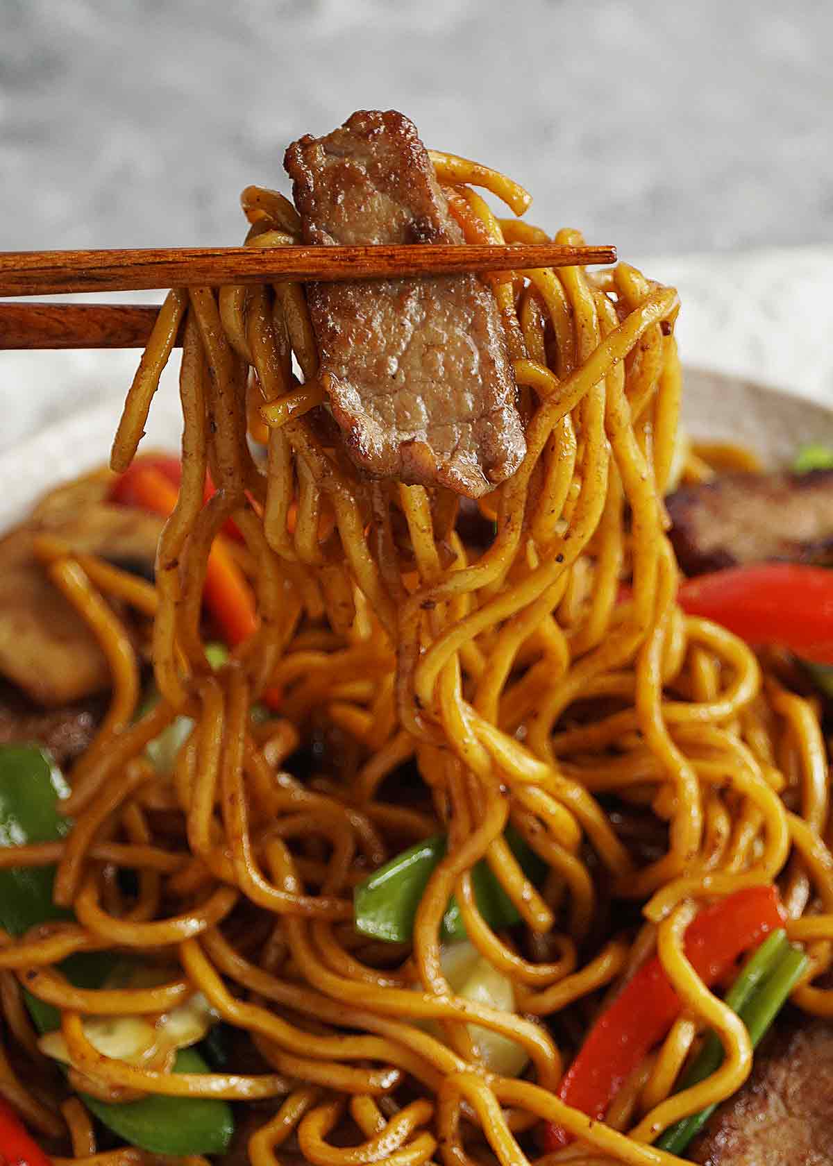 Stir fry beef slices and lo mein noodles and vegetables.