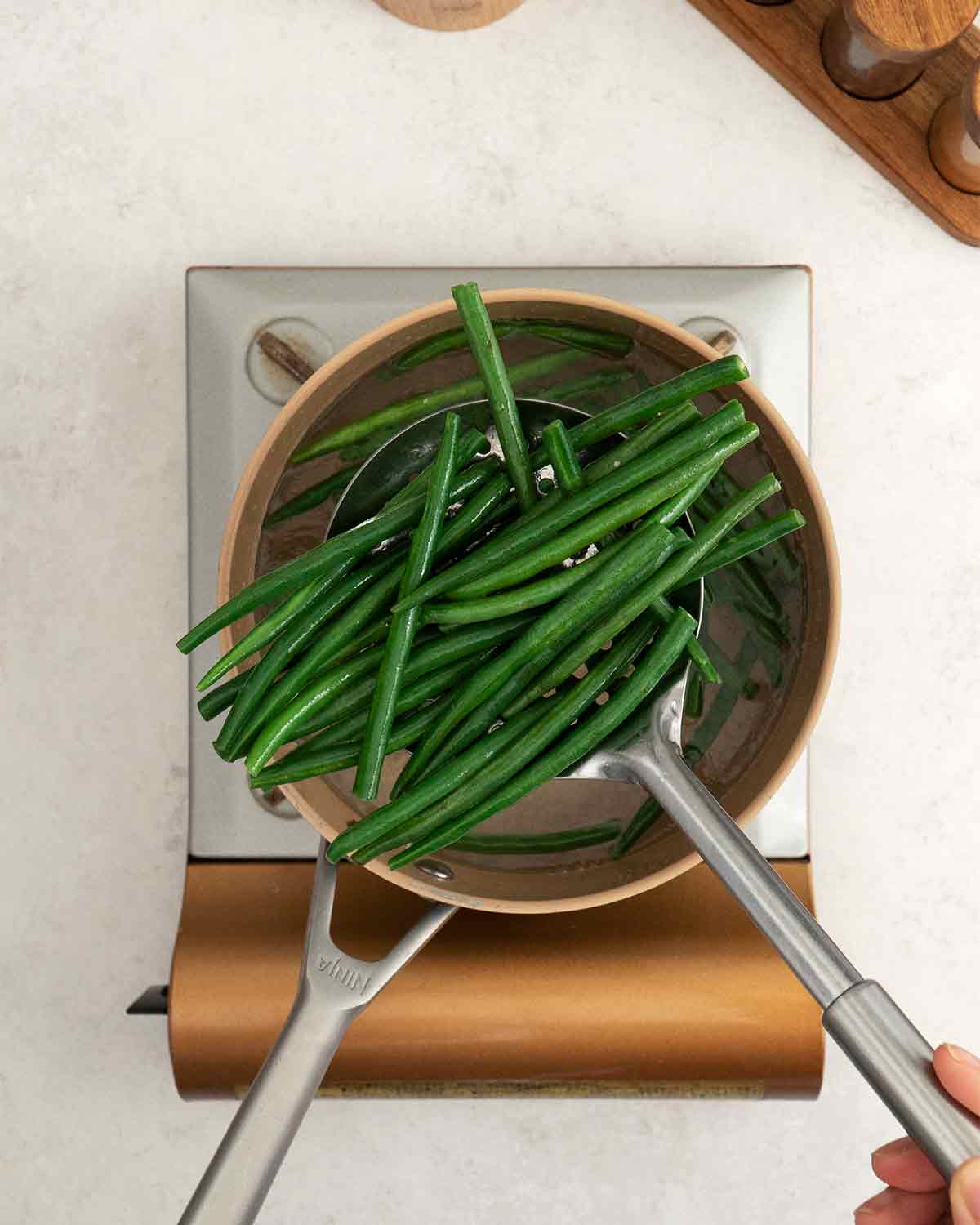 An image showing how to blanch green beans in hot water.