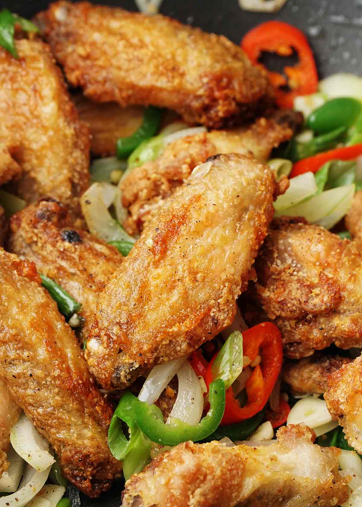 Fried golden chicken wings with Chinese salt and pepper seasonings and chilli pepper slices.