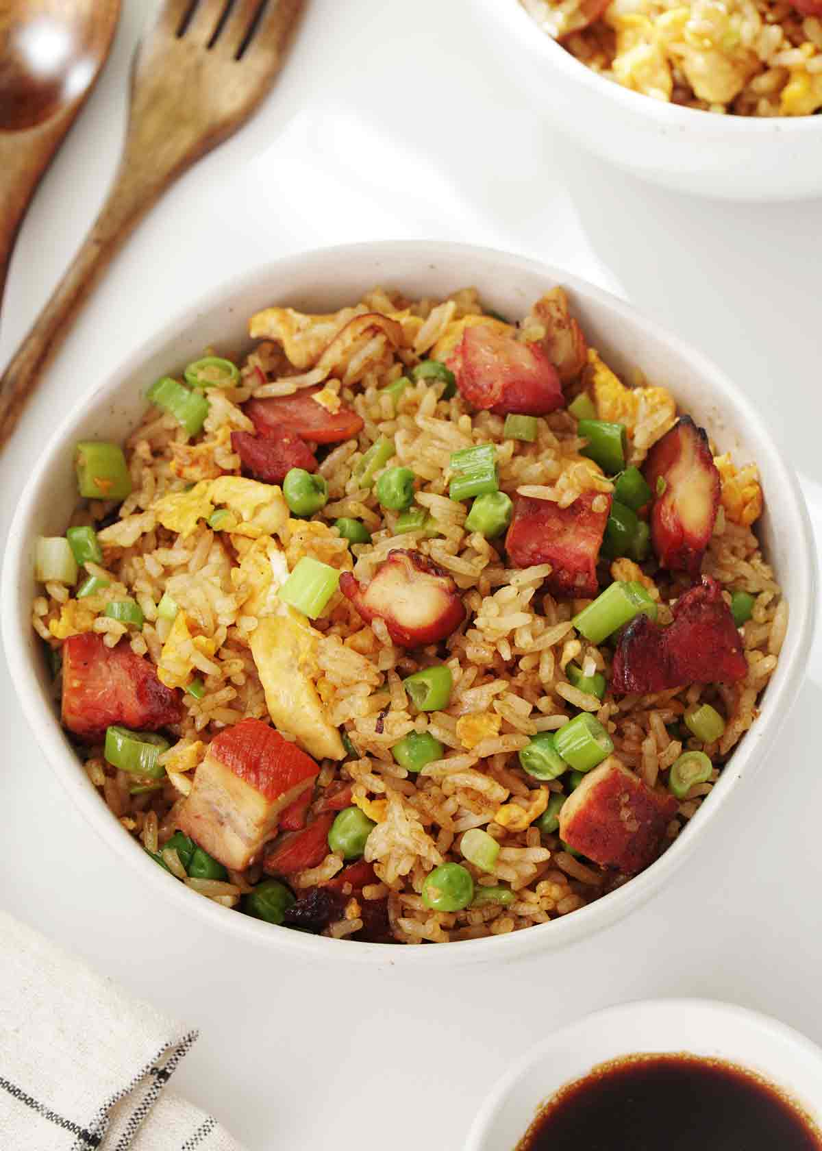 A small bowl containing fried rice with char siu chicken pieces and vegetables.