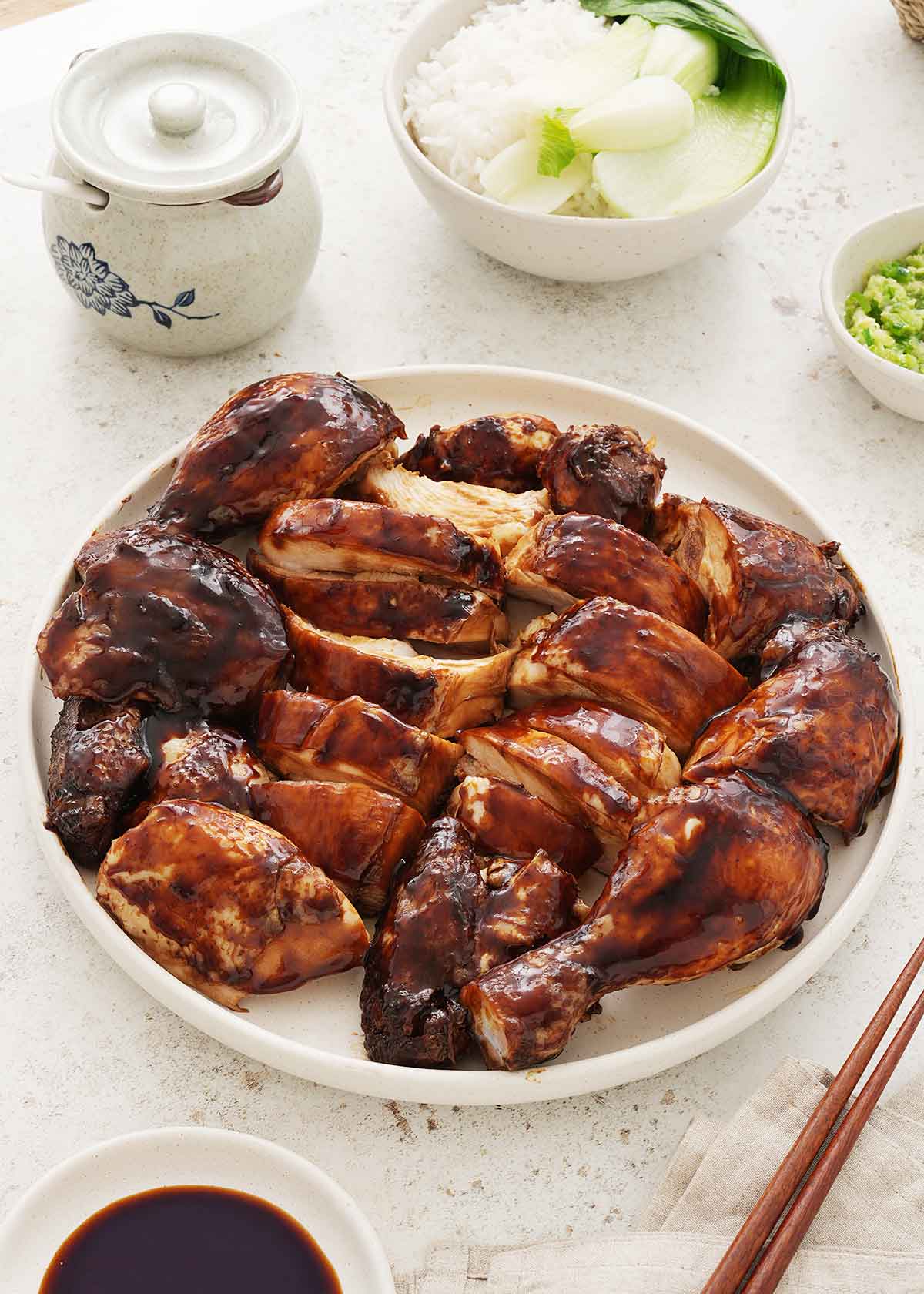 A white plate containing chopped soy sauce braised chicken pieces.