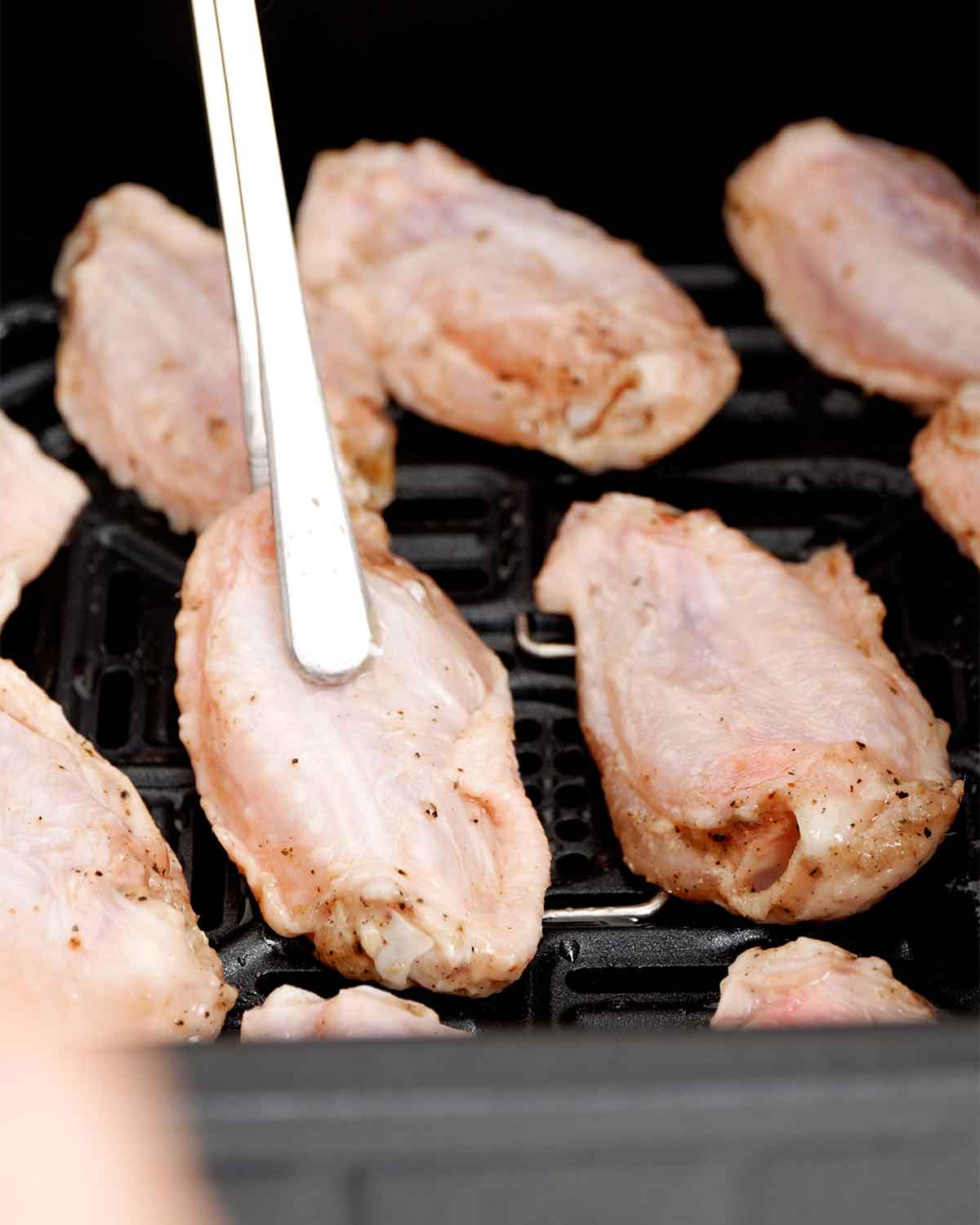 An image showing how to place chicken wings in an air fryer.