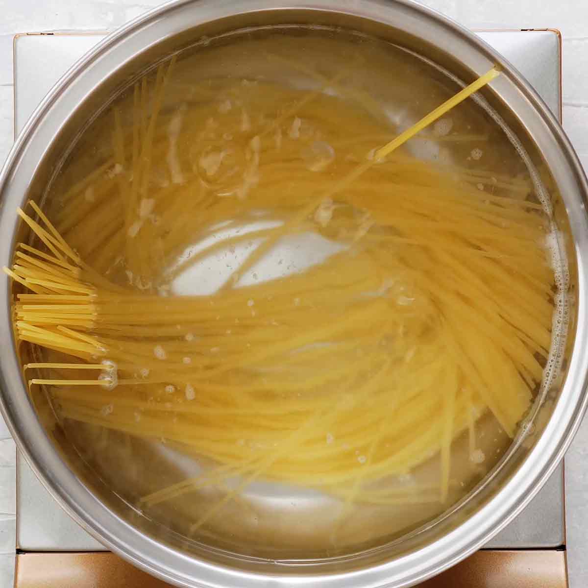 An image of a large pot boiling spaghetti noodles.