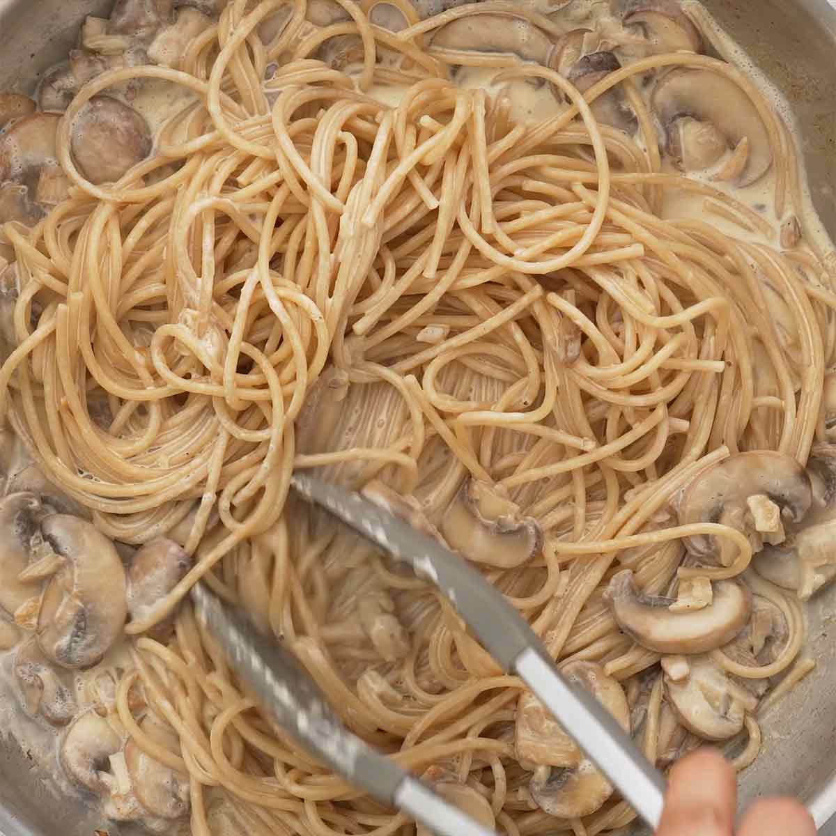 A large pan containing creamy mushroom sauce and pasta.