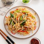 An image of a bean sprout stir fry dish displayed on a white plate.