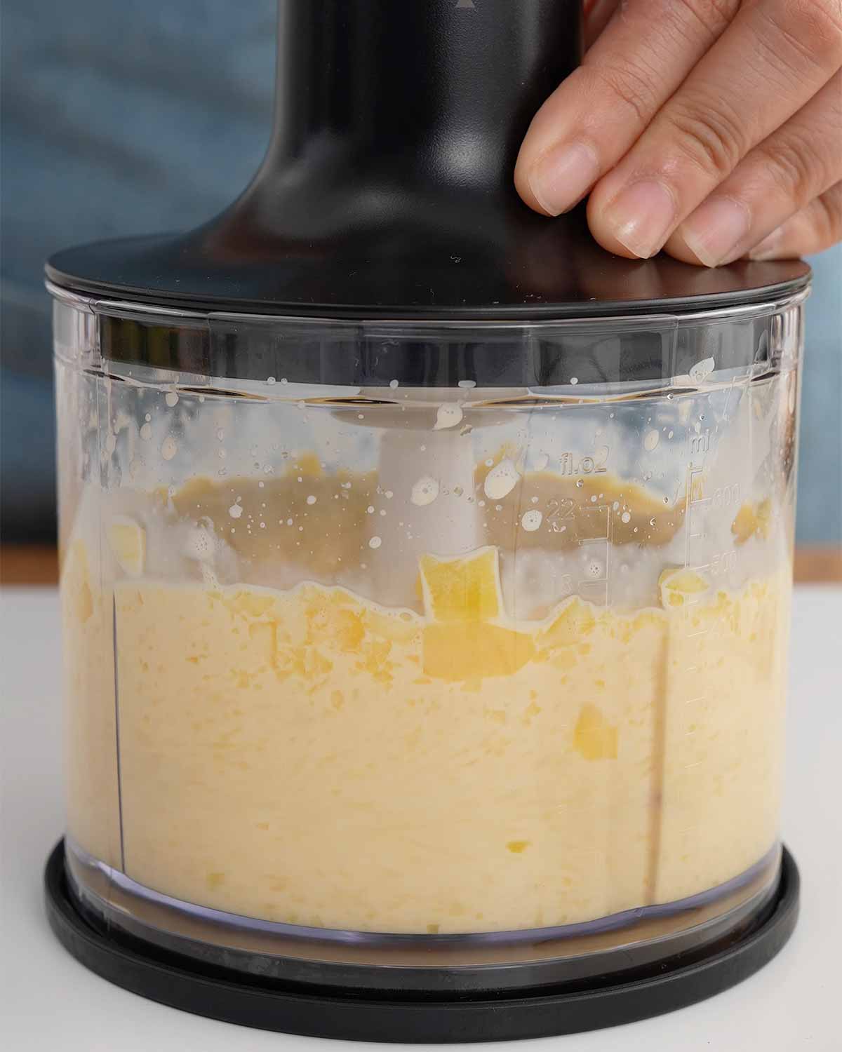 An image showing how to bland chopped mangoes in a food blender.